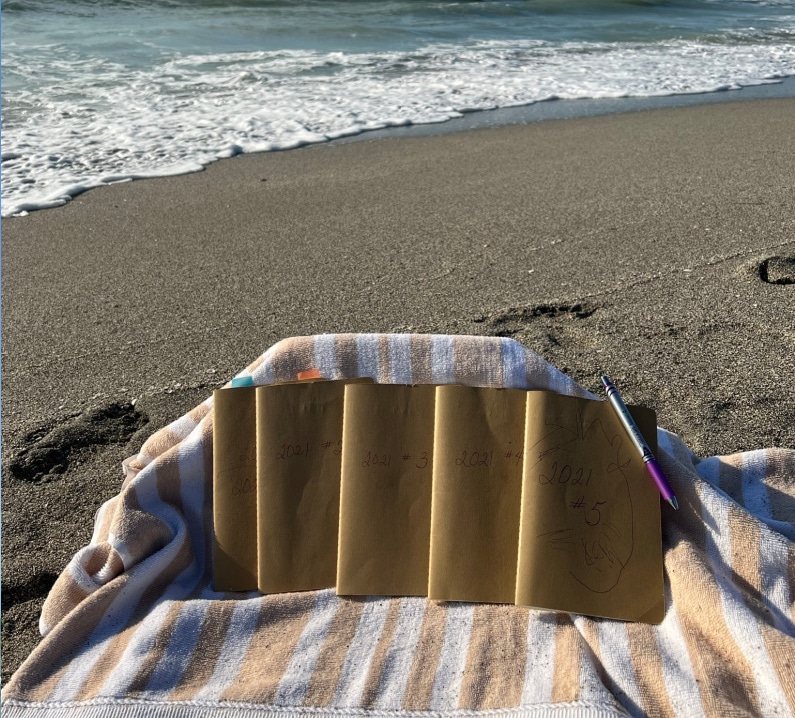 following joy-journals lined up on a chair by the ocean