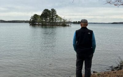 Photo of a man looking out over a lake.