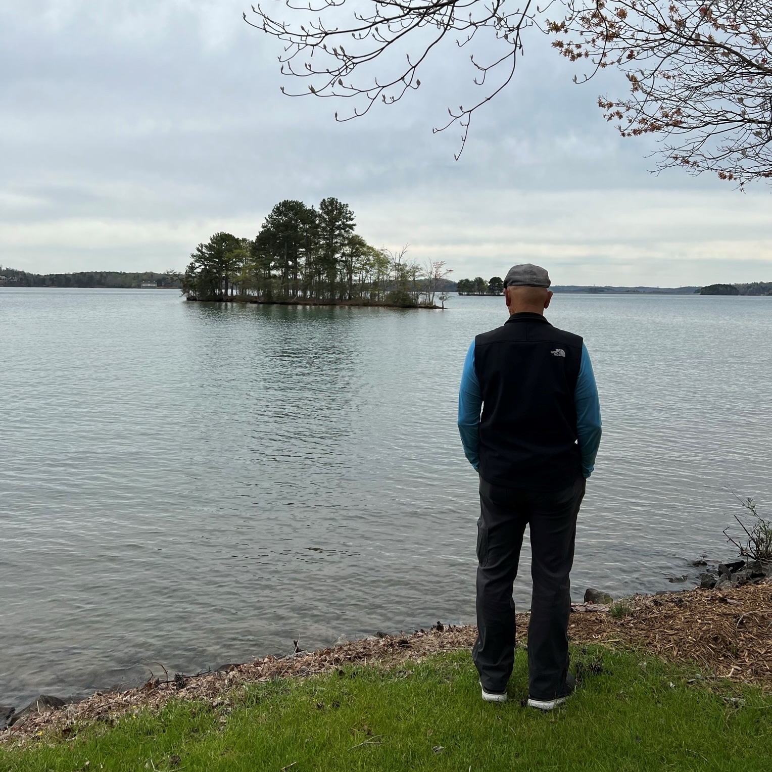 Photo of a man looking out over a lake.