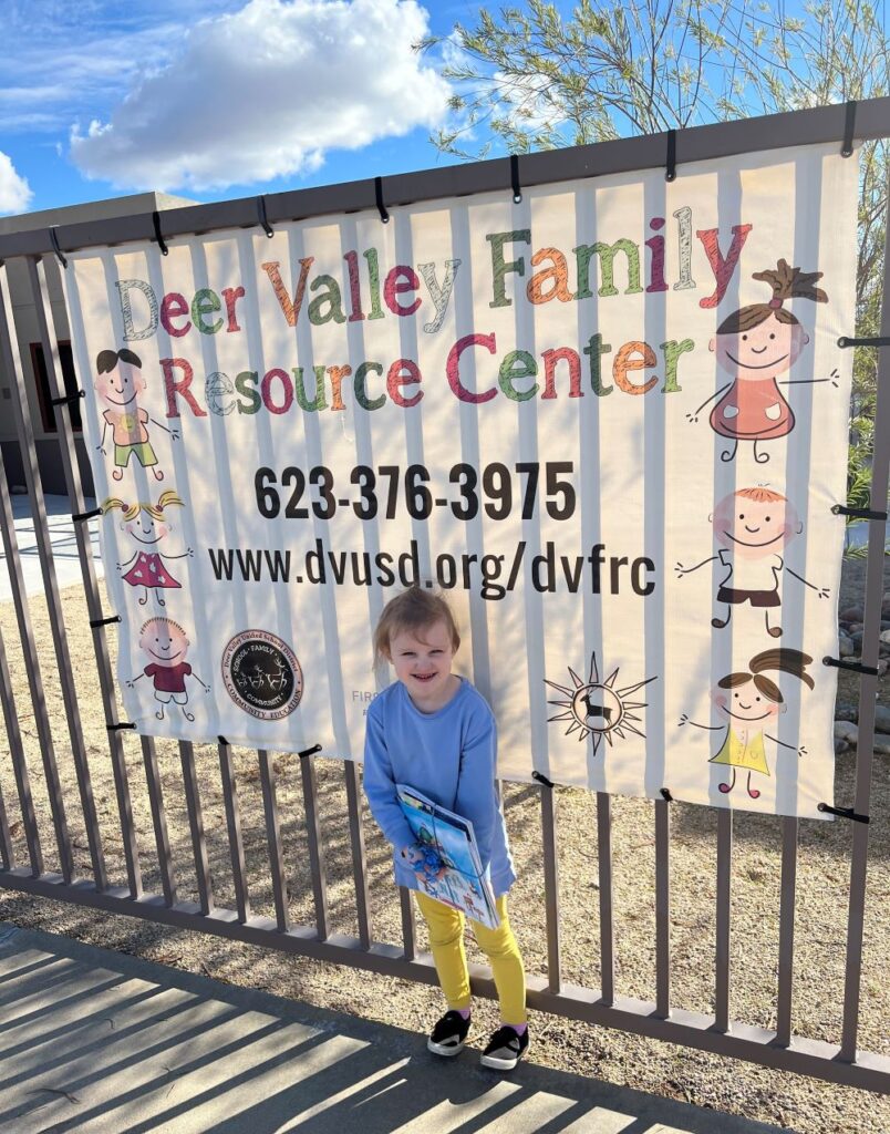 Four-year-old girl standing in front of a sign at Deer Valey Family Resource Center