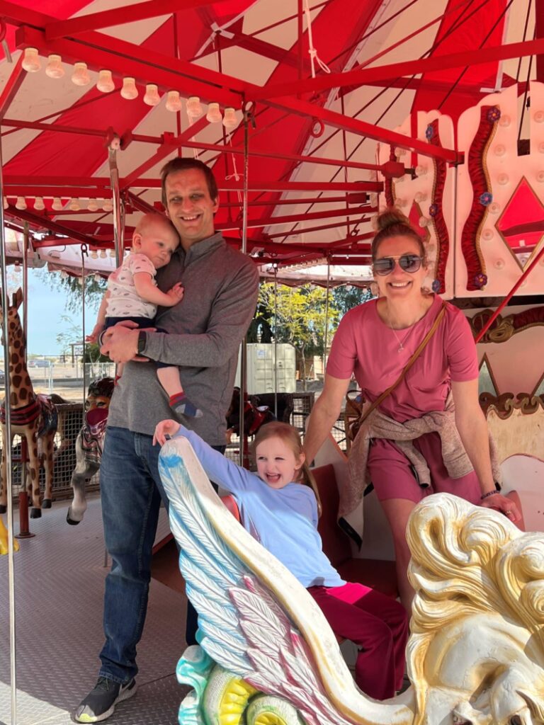 Daddy, aunt and two children on a carousel ride.