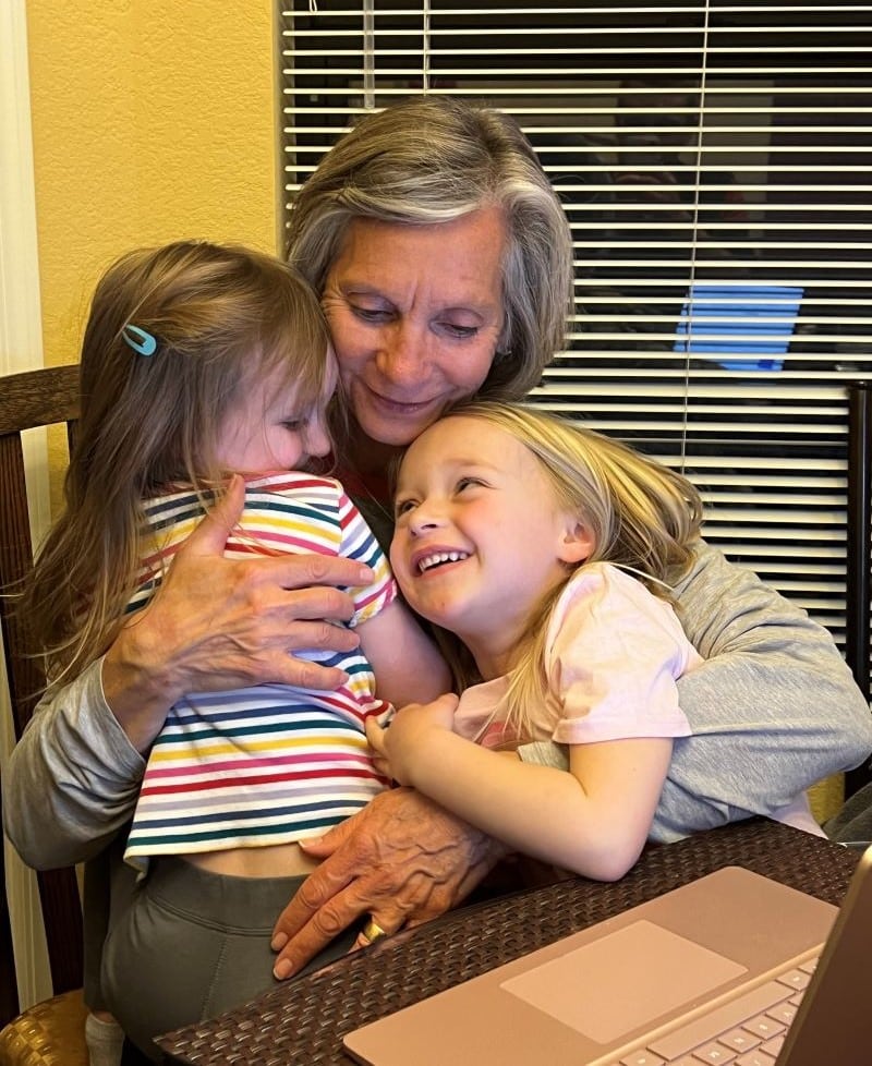 A Nana embracing her two granddaughters.