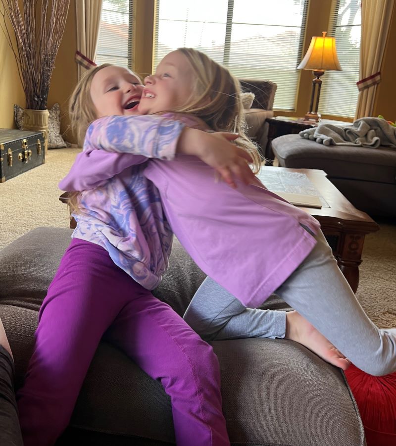 Two four-year-olds hugging each other.