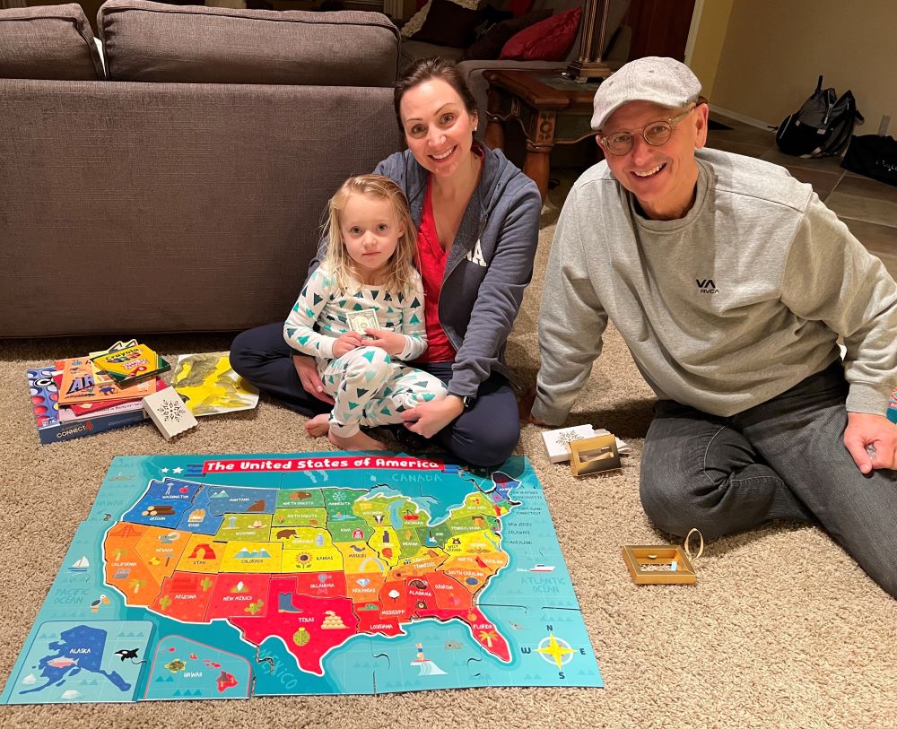 Papa with his daughter and granddaughter with a U.S. map puzzle.