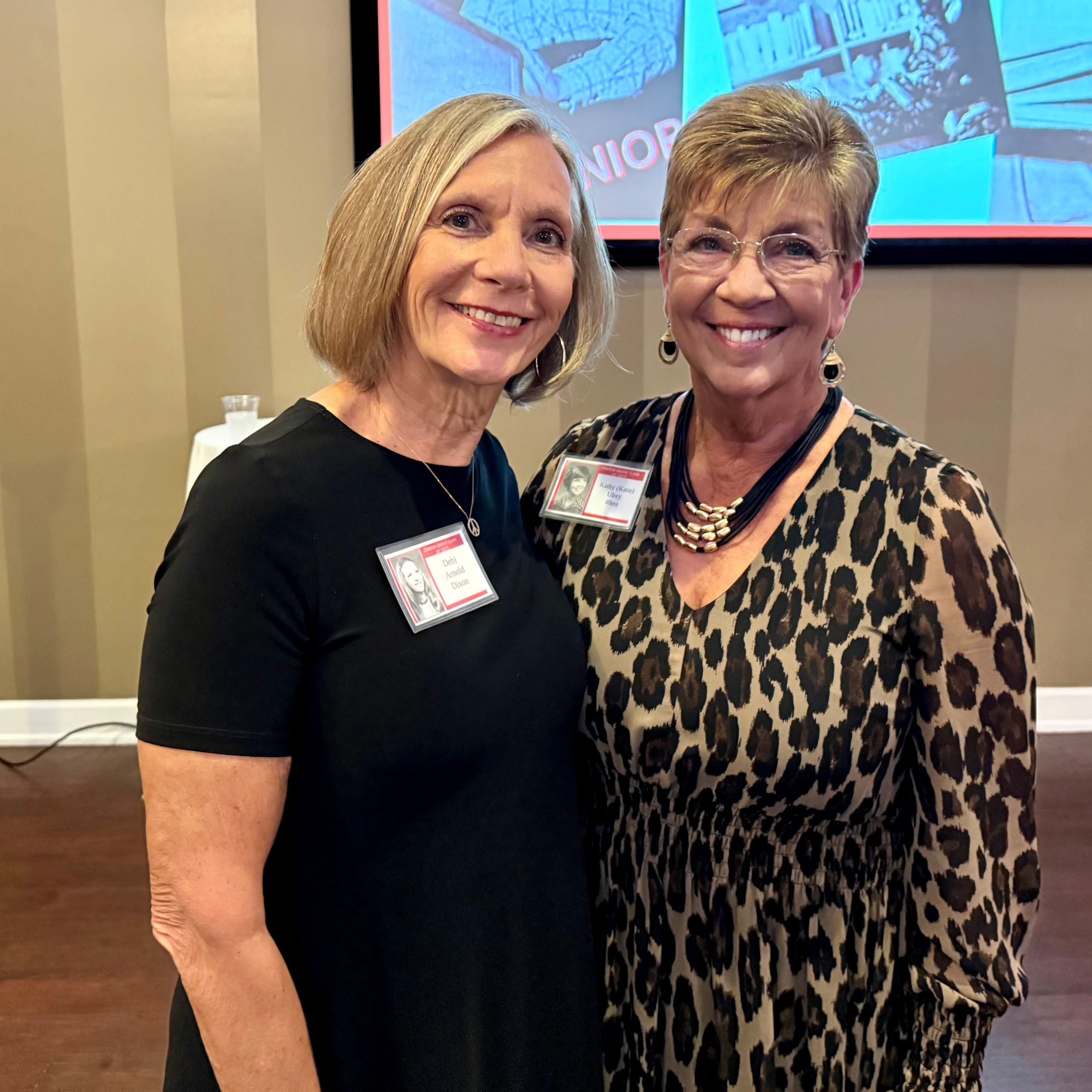 Two women, smiling at their 50th high school reunion